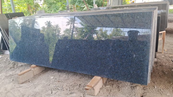 Polished dark blue-grey granite slabs outdoors