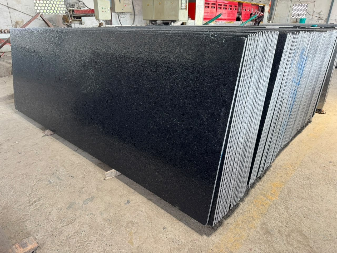 Stack of black granite slabs with a textured lappato finish in our yard