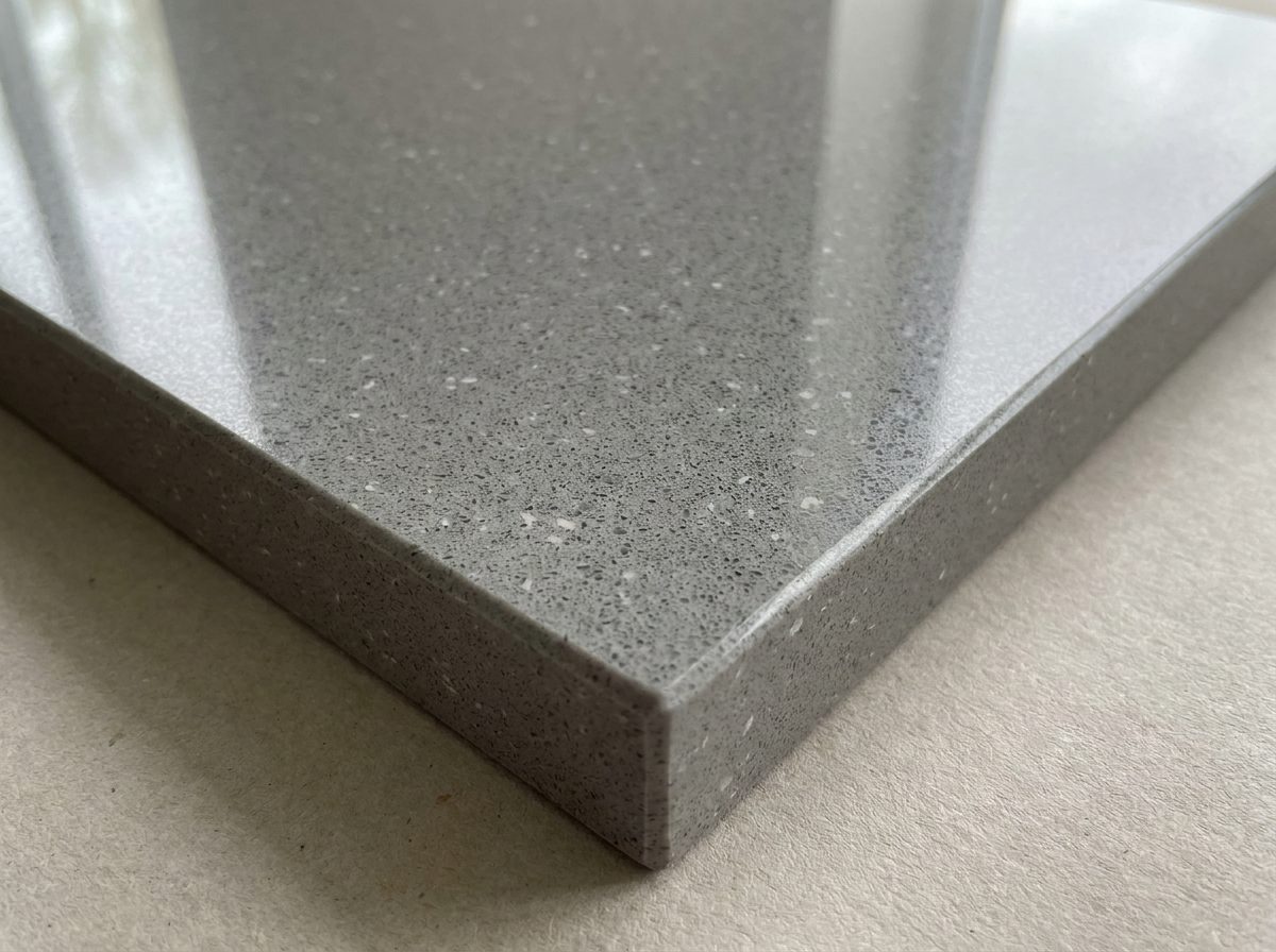 Polished grey engineered quartz with white and charcoal speckles